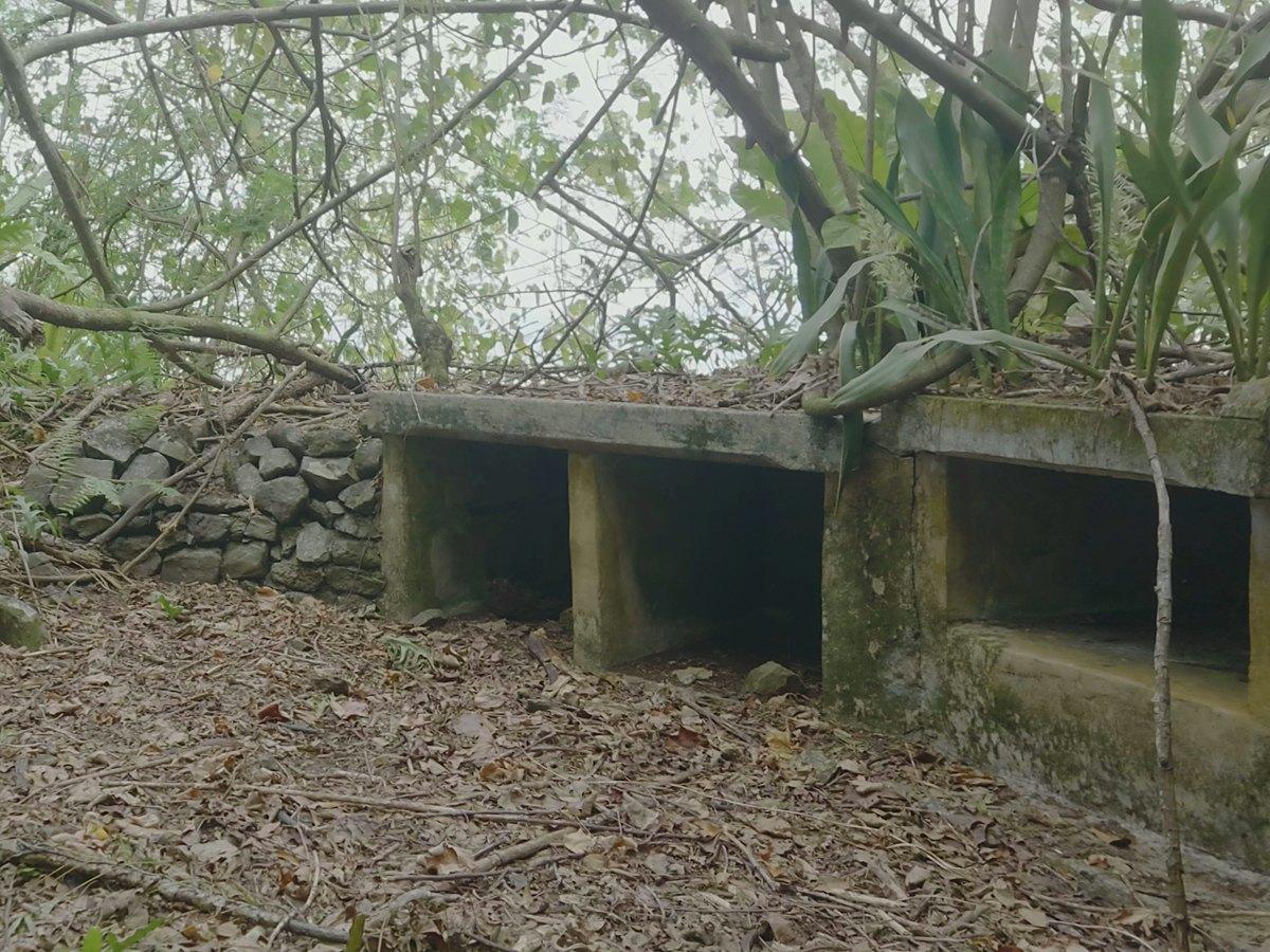 Ammunition magazines lining the stone revetment of an anti-aircraft battery